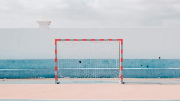 Bright sunny handball court with a vibrant goalpost. Perfect for sports or leisure themes.