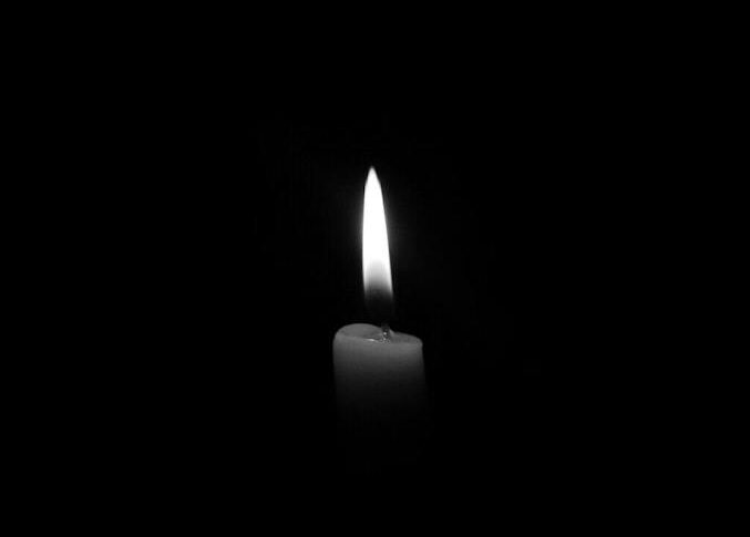 A solitary candle flame against a plain black backdrop, epitomizing simplicity and tranquility.