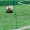 A soccer ball rests on a vibrant green field, ready for a match.
