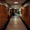 Vacant locker room with orange lockers and tiled flooring in a modern sports facility.