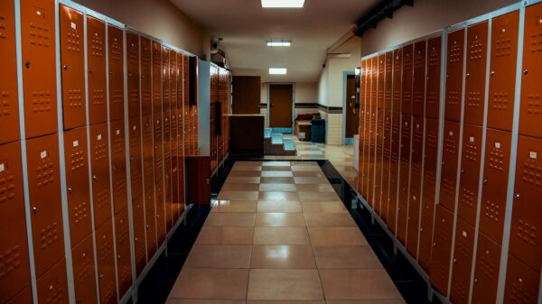 Vacant locker room with orange lockers and tiled flooring in a modern sports facility.
