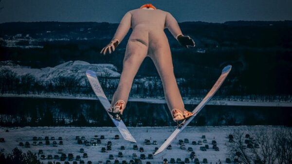 A thrilling shot of a ski jumper in mid-air against a snowy backdrop, showcasing winter sports excitement.