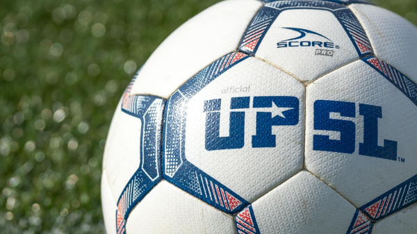 Detailed shot of a UPSL soccer ball on green grass, perfect for sports themes.