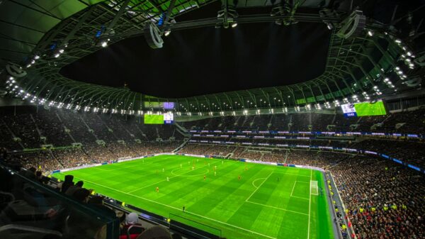 A captivating night football match at a packed stadium in England, showcasing dynamic gameplay and vibrant atmosphere.