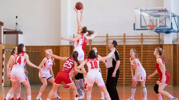 Exciting women's basketball game in a school gym, showcasing teamwork and athleticism.