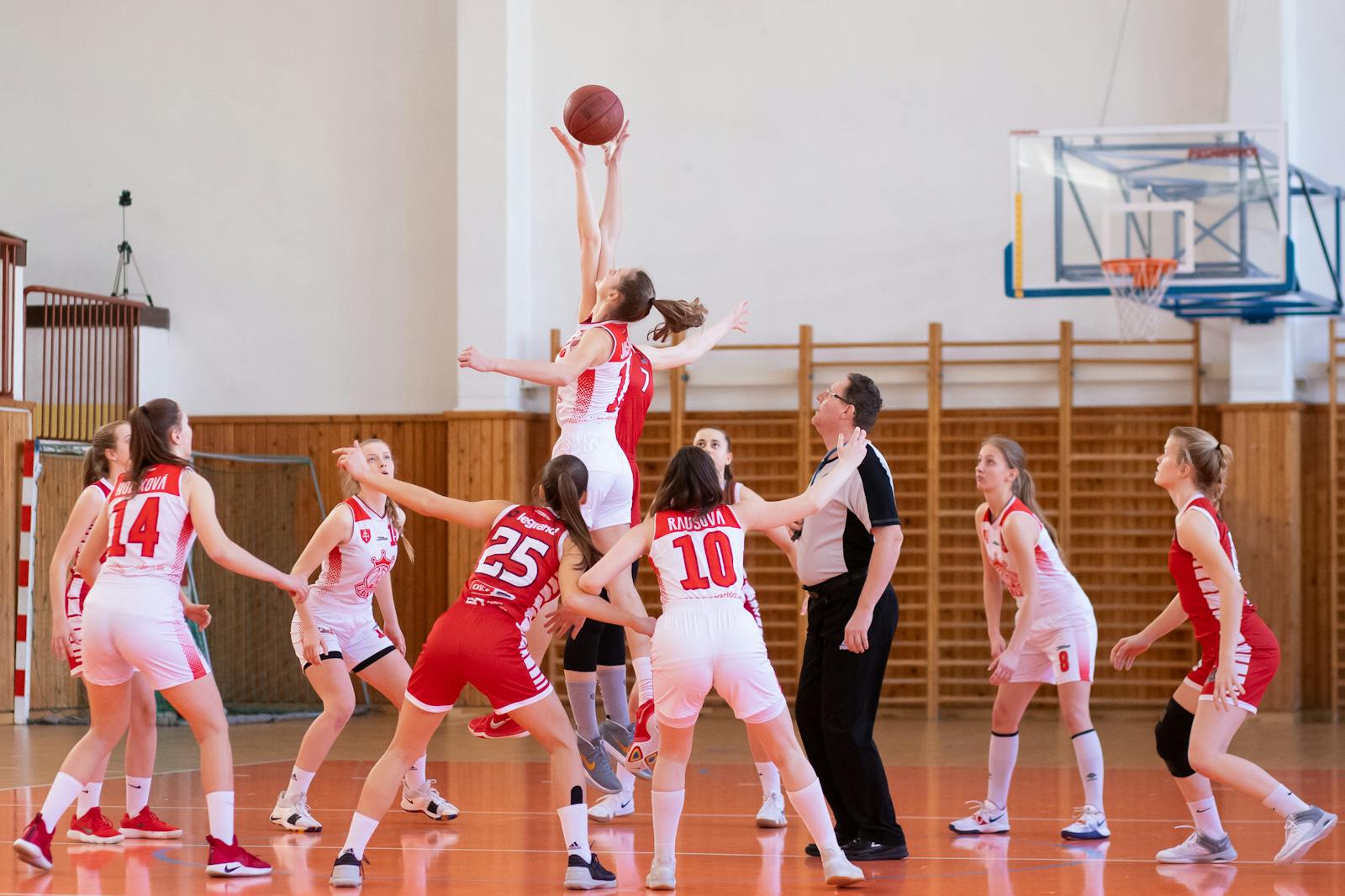 Exciting women's basketball game in a school gym, showcasing teamwork and athleticism.