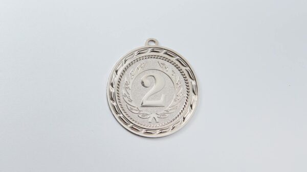 Close-up of a silver second place medal with an engraved number 2 on white background.