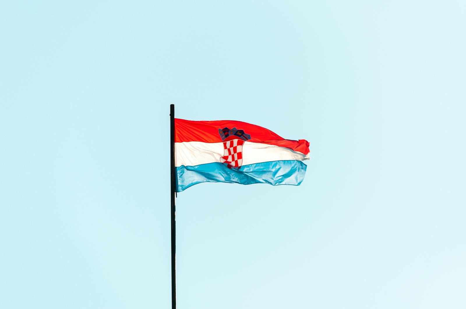 The national flag of Croatia waving against a blue sky in Trogir.
