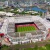 Stunning aerial view of Old Trafford Stadium in Manchester, showcasing its modern architecture and bustling cityscape.