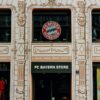 FC Bayern Store front in Munich showcasing the iconic Bayern Munich logo and architectural details.
