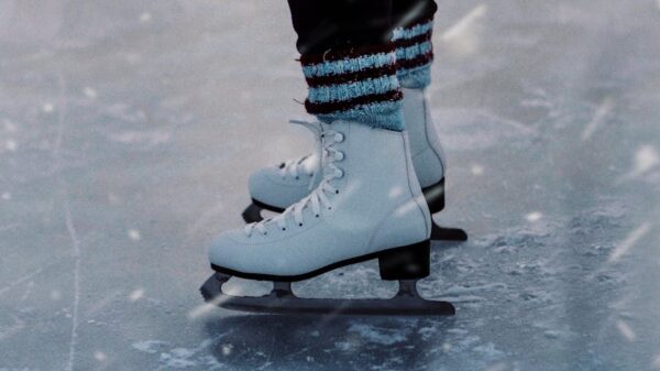 Close-up of person ice skating outdoors, showcasing ice skates in winter setting.