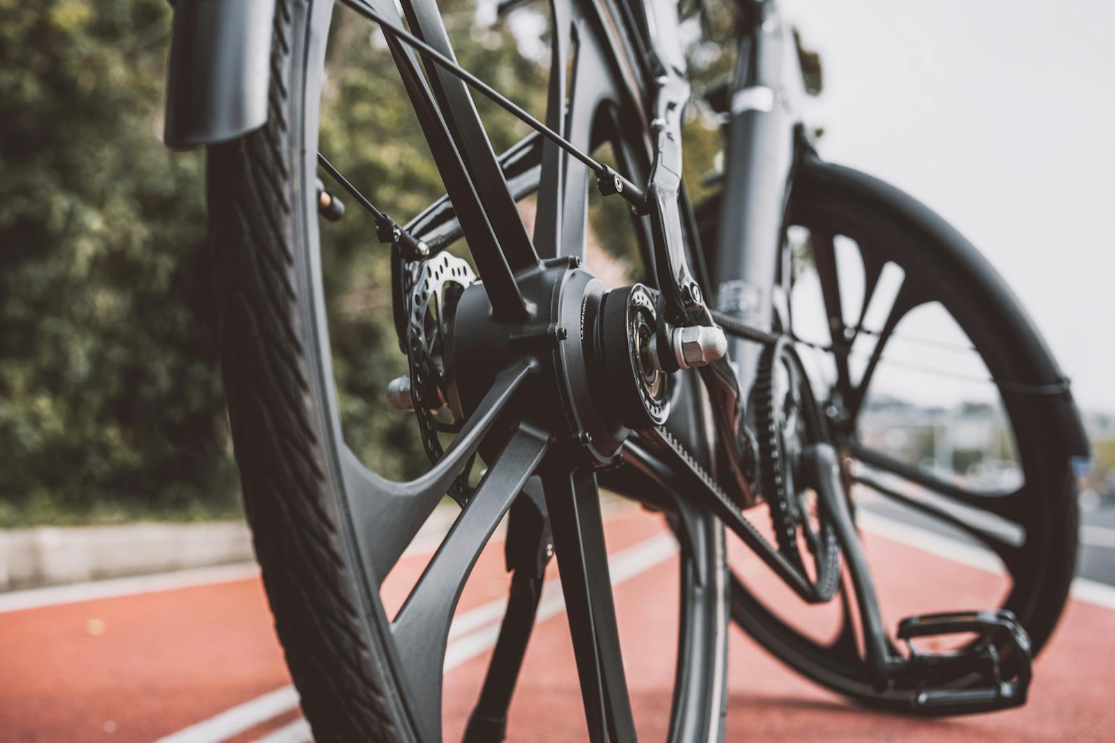 Detailed view of a bicycle wheel on a red urban bike path, showcasing modern design.