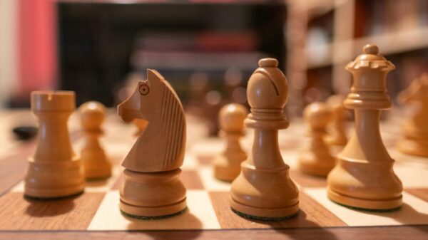 Close-up of wooden chess pieces on a chessboard in a cozy indoor setting.