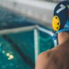 A water polo player prepares near the goal in an indoor swimming pool.
