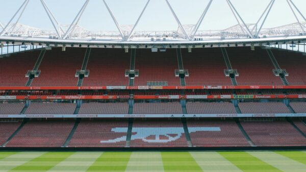 View of Arsenal's iconic Emirates Stadium with empty stands and lush football pitch.