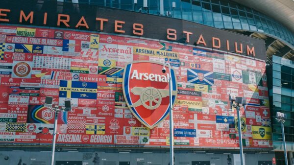 Vibrant wall art at Emirates Stadium featuring Arsenal flags and crest in London, UK.