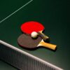 Table tennis paddles and ball on a green table. Ideal for sports themes.