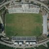 High-angle aerial shot capturing the details of a soccer stadium and surrounding sports complex.