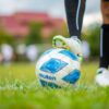 A detailed shot of a player’s foot on a soccer ball during a game, emphasizing sport and movement.