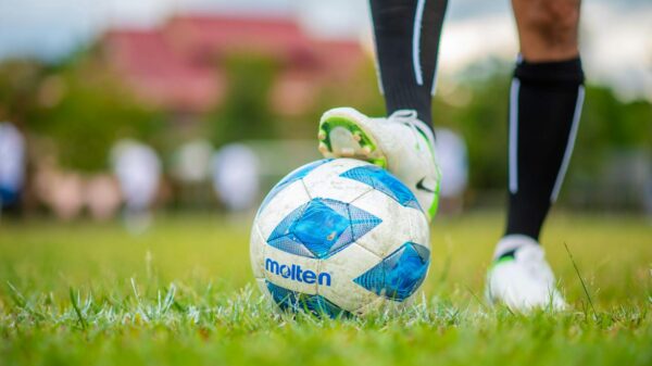 A detailed shot of a player’s foot on a soccer ball during a game, emphasizing sport and movement.