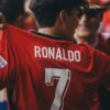 A passionate soccer fan wearing a Ronaldo jersey celebrates at a sports event.