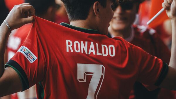 A passionate soccer fan wearing a Ronaldo jersey celebrates at a sports event.