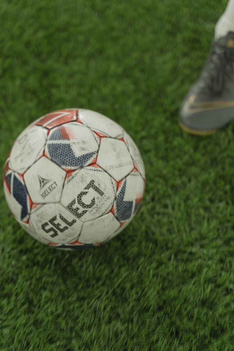 A close-up of a soccer ball on a lush green field, perfect for sports enthusiasts.