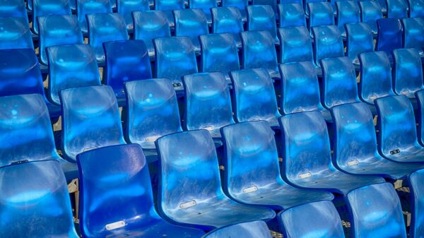 Vibrant blue plastic seats in a stadium forming a pattern, offering ample copy space.