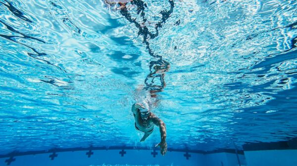 Dynamic underwater view of a swimmer practicing freestyle in a clear pool.