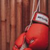 Striking red boxing gloves on a wooden background, symbolizing strength and determination.