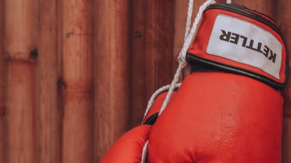 Striking red boxing gloves on a wooden background, symbolizing strength and determination.