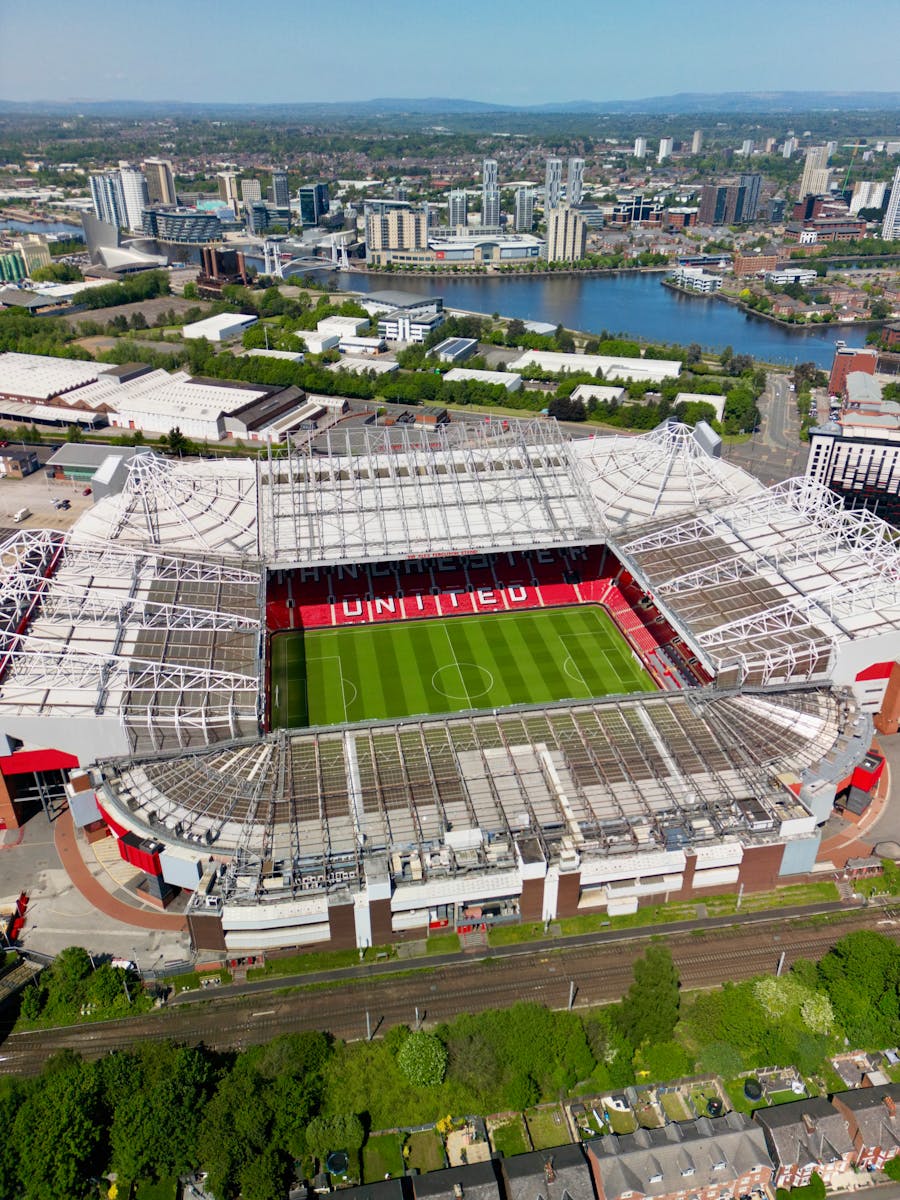 Stunning aerial view of Old Trafford Stadium in Manchester, showcasing its modern architecture and bustling cityscape.