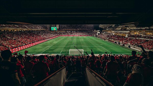 An exciting football match with passionate fans filling the stadium under bright lights, capturing sports energy.