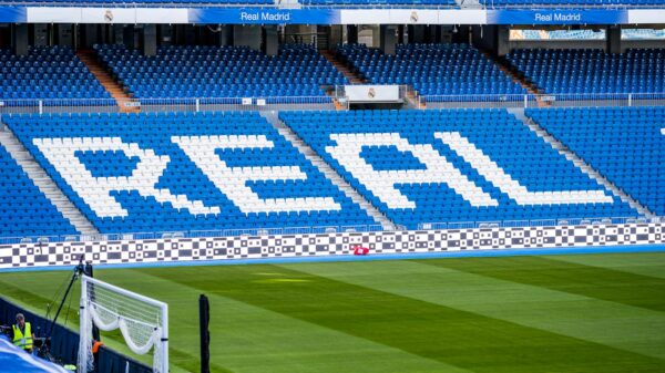 Empty seating area in Real Madrid's stadium with 'REAL' prominently displayed in white.