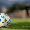Close-up of an official Argentine soccer ball resting on a green field with a blurred background.