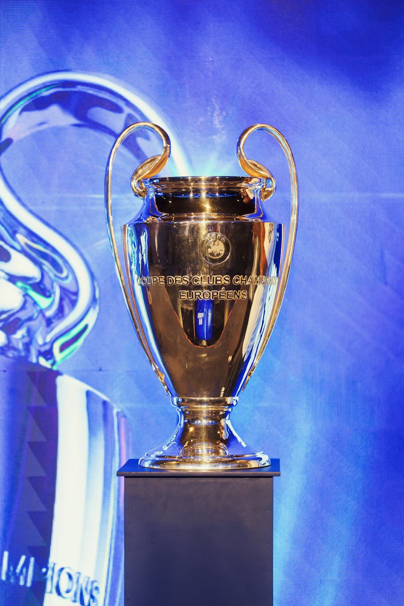 Close-up of the UEFA Champions League trophy on a pedestal indoors.