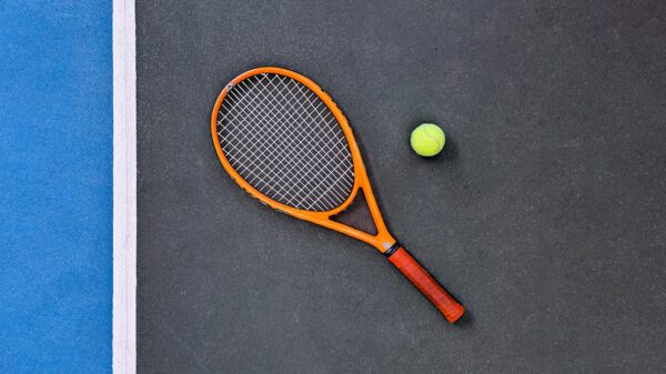 A tennis racket and ball on a court, emphasizing sports equipment essentials.