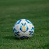 Close-up of a soccer ball on a grassy field, perfect for sports-themed designs.