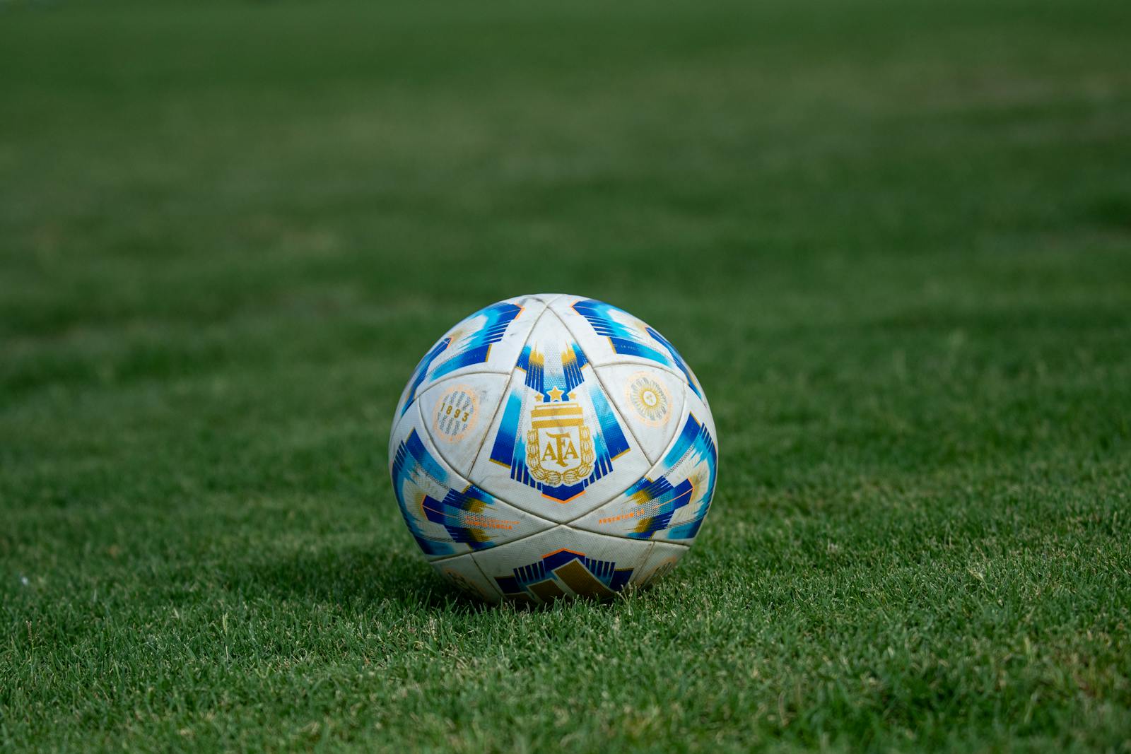 Close-up of a soccer ball on a grassy field, perfect for sports-themed designs.