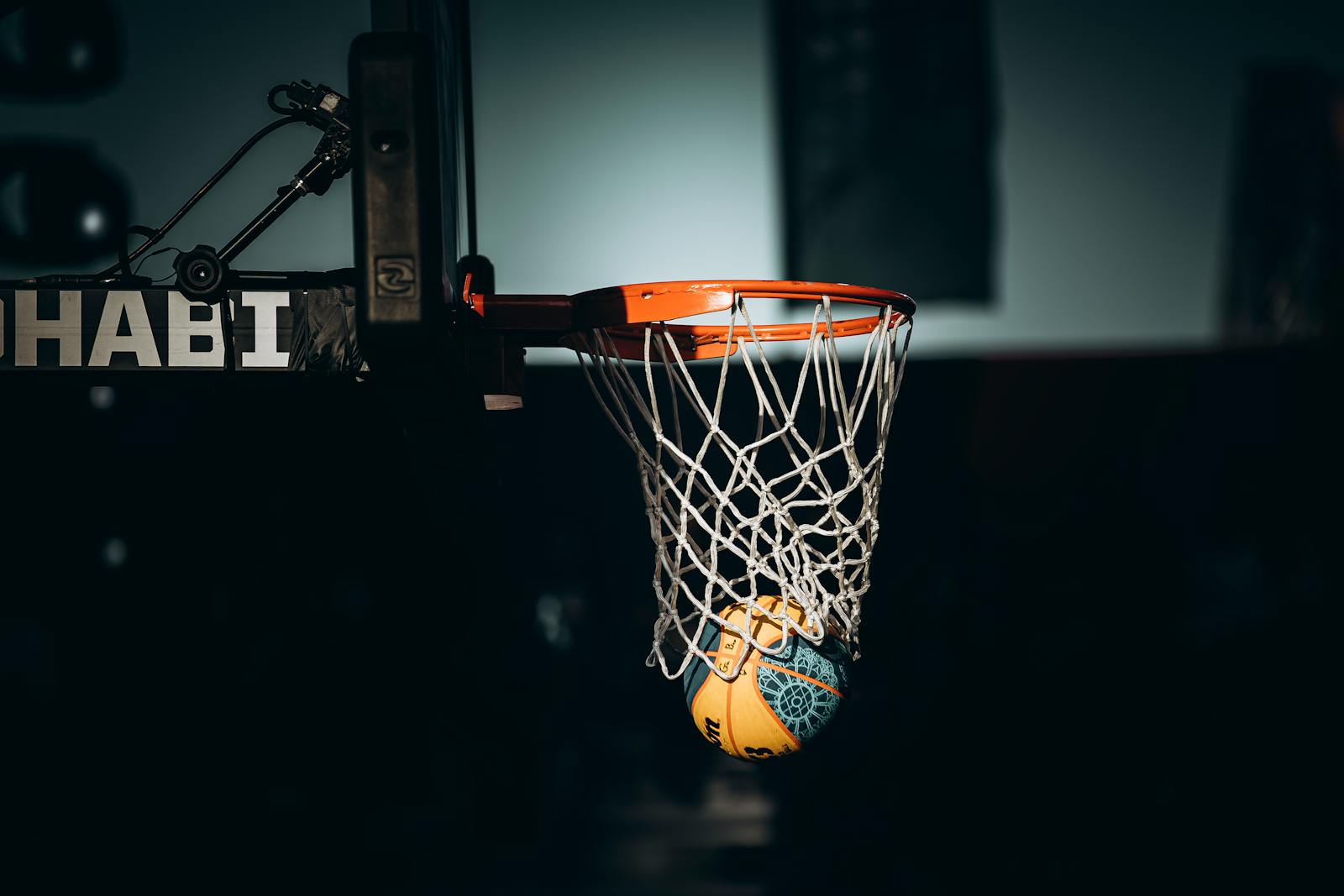Dramatic basketball dunk captured in Abu Dhabi sports arena.