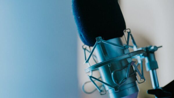 Close-up of a studio microphone with a blue backdrop, ideal for podcasts or recording.