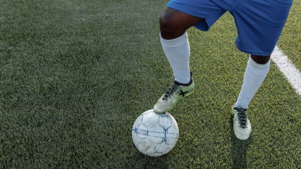 Close-up of a player controlling a soccer ball on a grass field.