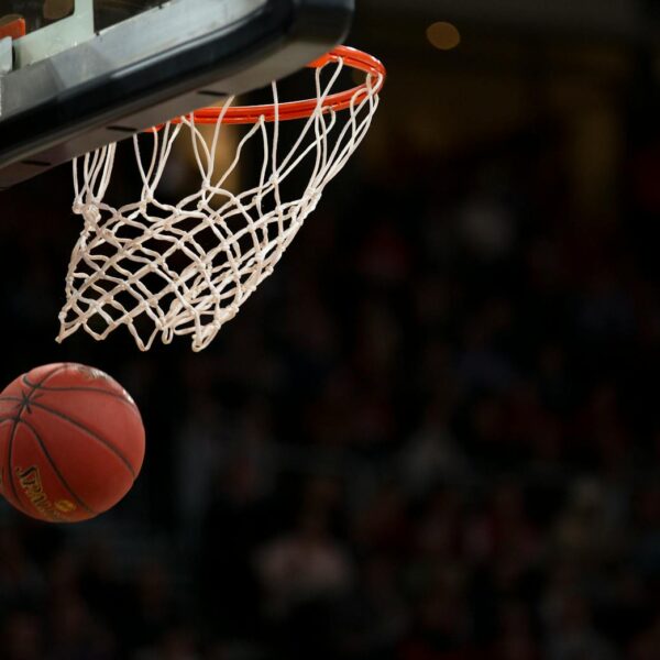 A basketball going through the hoop during a fast-paced game, capturing the excitement of the sport.