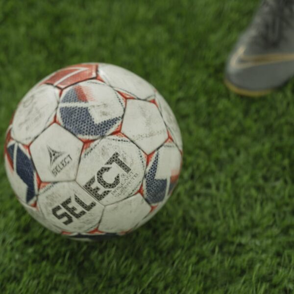 A close-up of a soccer ball on a lush green field, perfect for sports enthusiasts.