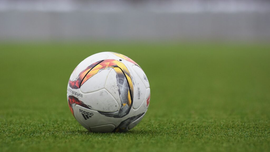 white and gray Adidas soccerball on lawn grass