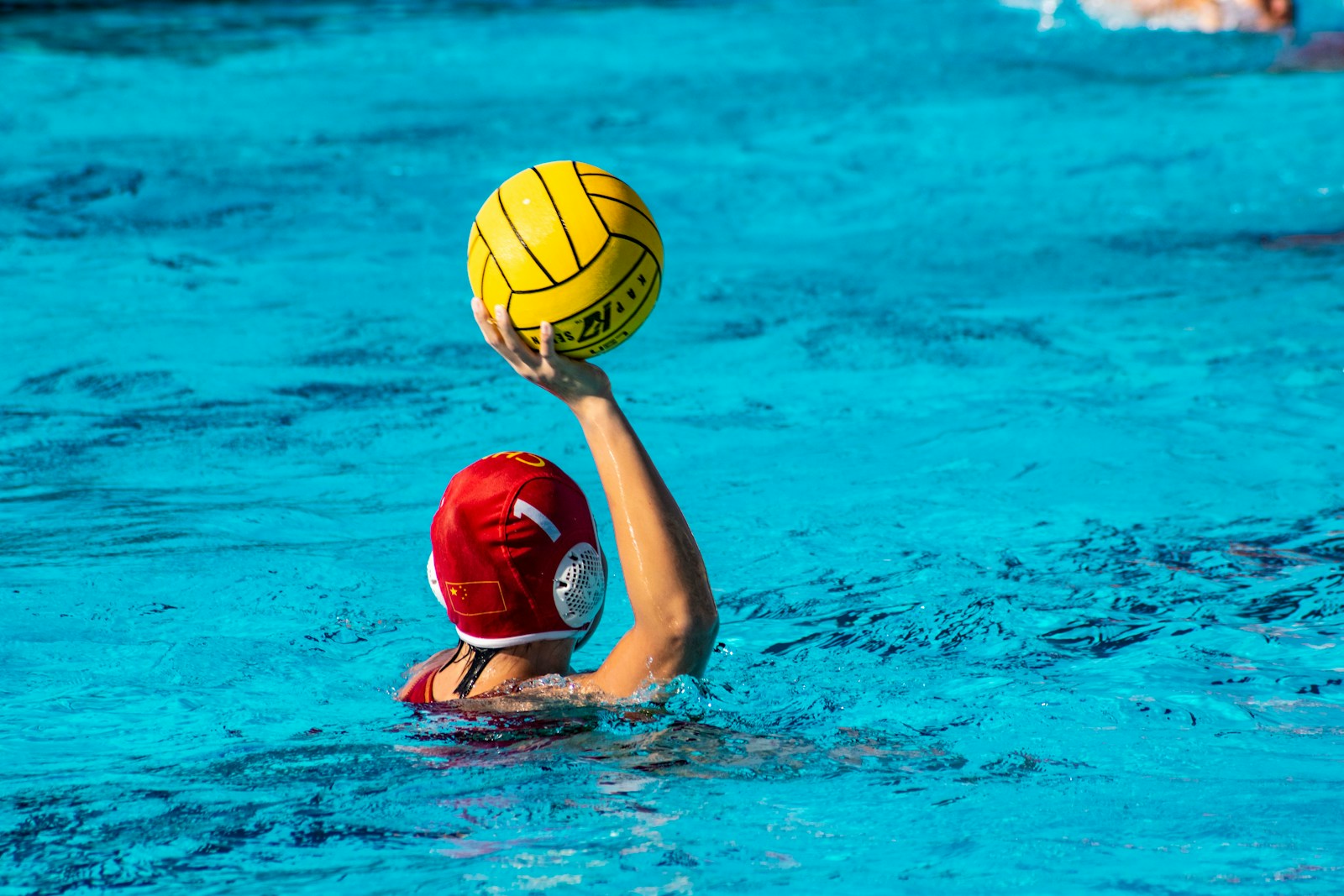 a person in a pool with a ball in their hand