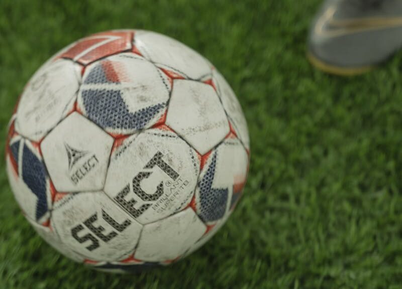 A close-up of a soccer ball on a lush green field, perfect for sports enthusiasts.