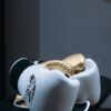 White and gold boxing gloves resting elegantly on a black surface, highlighting their premium quality.
