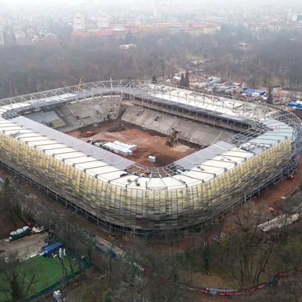 Aerial view of stadium under construction with surrounding trees