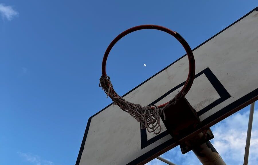 Basketball hoop silhouetted against a clear sky with the moon visible in Antalya, Türkiye.